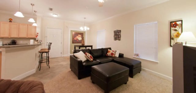 L-shaped sofa ottoman and kitchen counter Living room at Stratford Court Luxury Apartments in Gainesville Student Accommodation