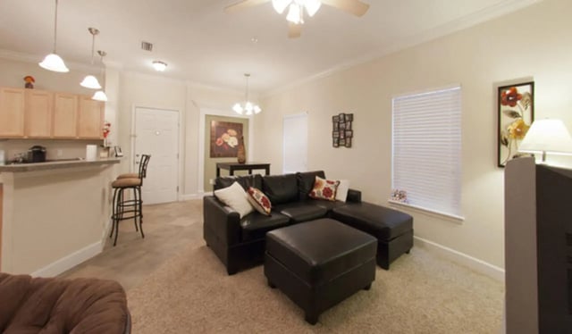 Leather sectional couch ottoman bar stools and cabinets living room at Stratford Court Luxury Apartments in Gainesville Student Accommodation