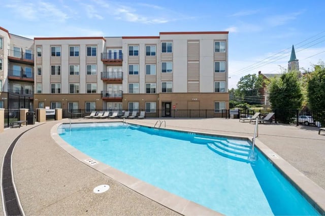 Building with pool lounge chairs and trees exterior at The Eden Apartments in Cincinnati Student Accommodation