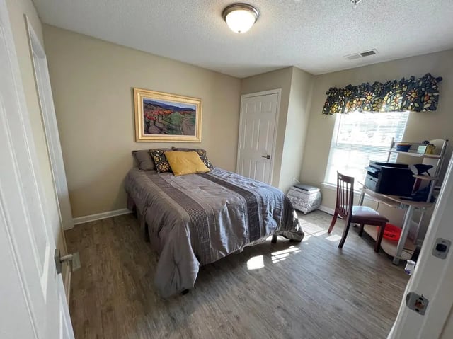 Bed with painting desk and printer bedroom at Campus East Apartments in Greensboro Student Accommodation
