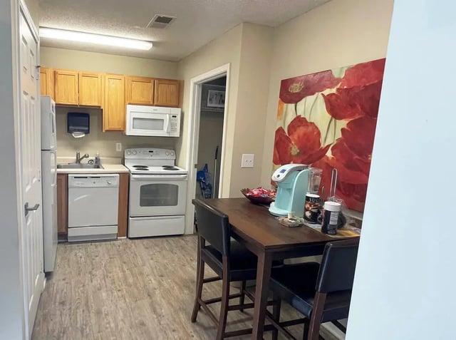 Kitchen with appliances table chairs and artwork kitchen at Campus East Apartments in Greensboro Student Accommodation