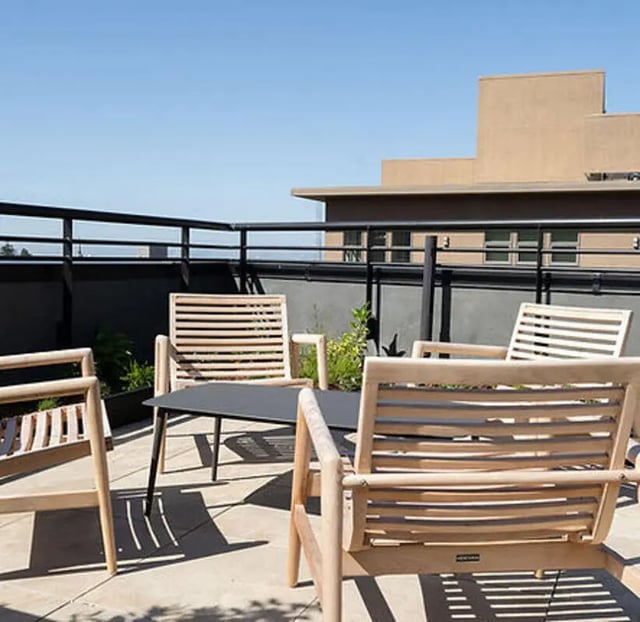 Wooden chairs and table on patio exterior at Aquatic at U in Berkeley Student Accommodation