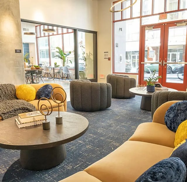 Yellow sofa with blue cushions communal living area at Aquatic at U in Berkeley Student Accommodation