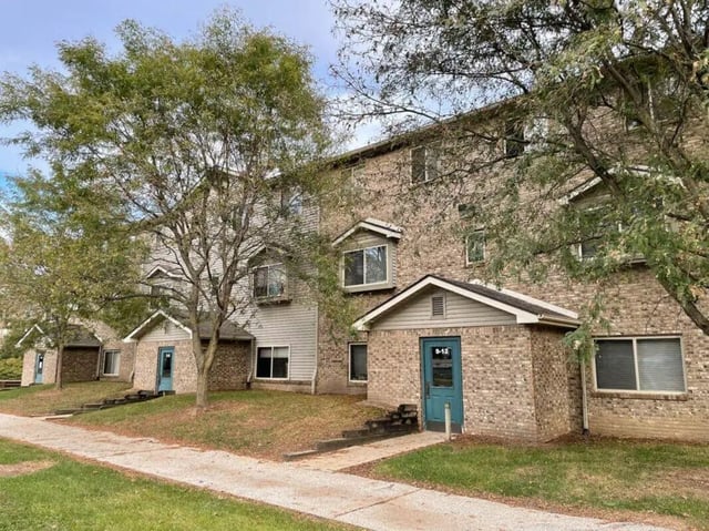 Brick buildings with blue doors green grass exterior at Crestview Apartments in West Lafayette Student Accommodation