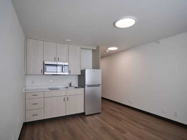 Light wood cabinets microwave refrigerator kitchen area at Abigail Court in Gresham Student Accommodation