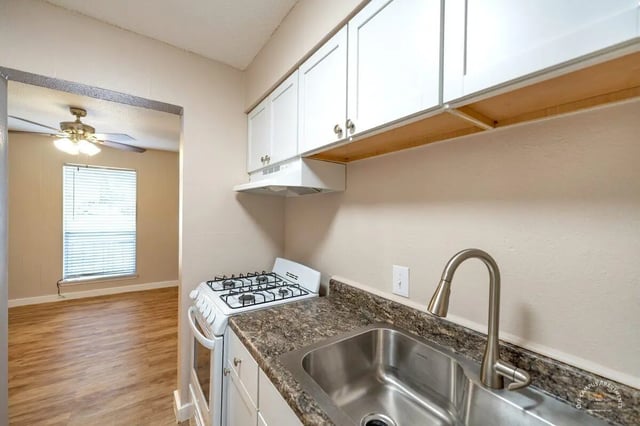 White cabinets stove sink and adjoining room kitchen at Barranca Square Student Apartments in Austin Student Accommodation