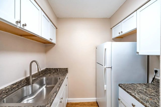 White cabinets sink refrigerator kitchen area at Barranca Square Student Apartments in Austin Student Accommodation
