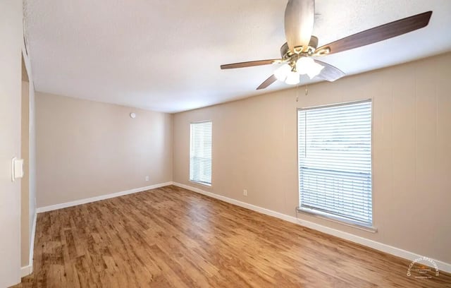 Ceiling fan wood floor two windows empty living room at Barranca Square Student Apartments in Austin Student Accommodation