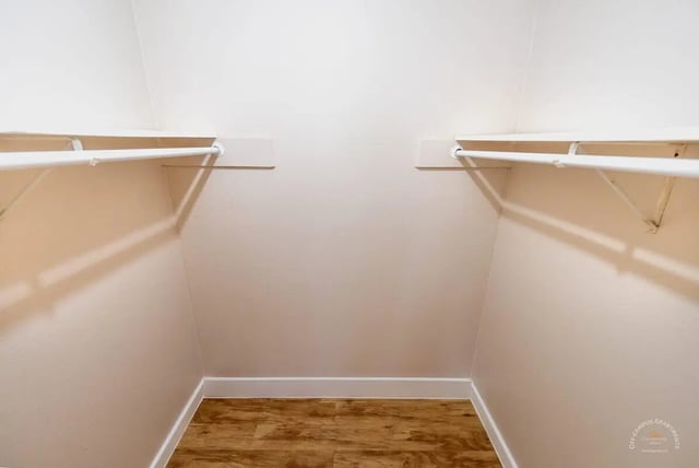Empty closet with hanging rods and wood floor closet at Barranca Square Student Apartments in Austin Student Accommodation