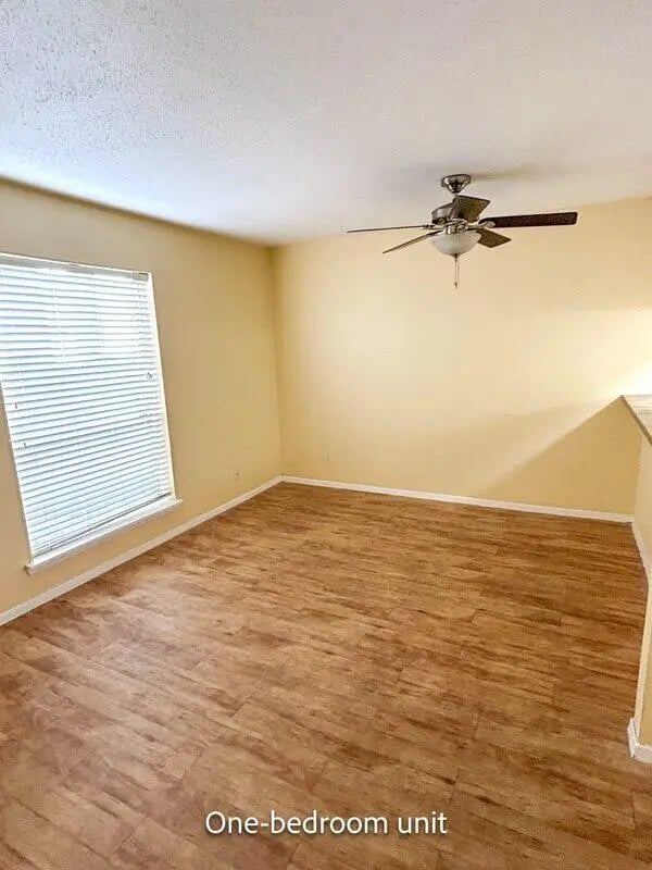 Empty room with wood floor and ceiling fan Living room at Barranca Square Student Apartments in Austin Student Accommodation