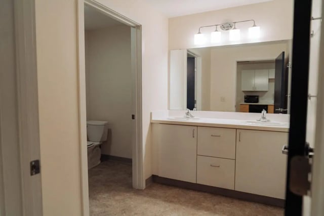 Toilet and dual vanity sinks bathroom at Copper Beech Commons Student Housing in Syracuse Student Accommodation