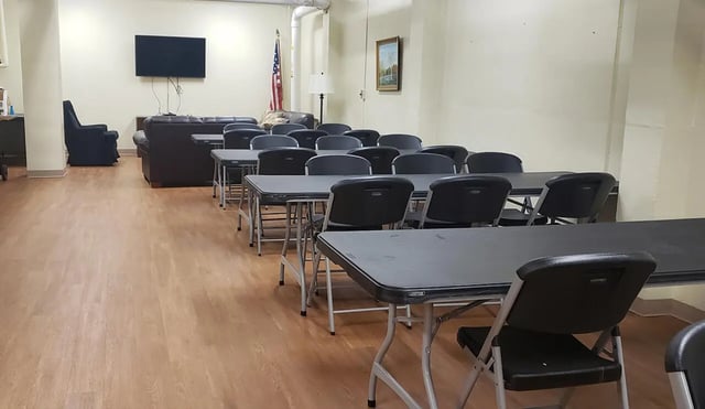 Rows of tables and chairs with couches living room at 100 Chenango Place in Binghamton Student Accommodation