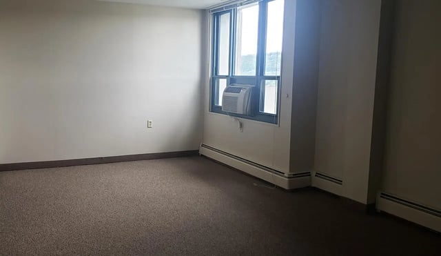 Empty room window air conditioner and heaters living room at 100 Chenango Place in Binghamton Student Accommodation
