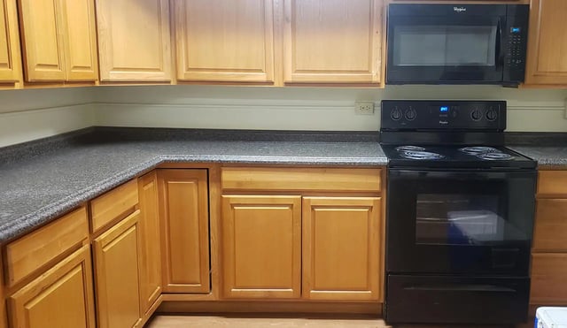 Wooden cabinets black microwave and stove kitchen at 100 Chenango Place in Binghamton Student Accommodation