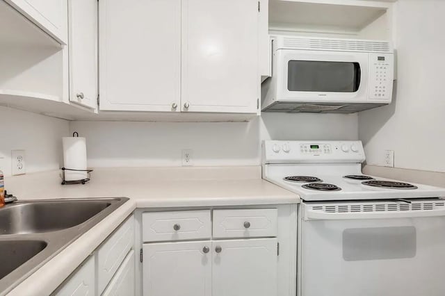 White cabinets stove microwave sink kitchen at Barristers Hall in Macon Student Accommodation