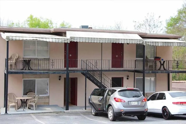 Building exterior with balconies and parked cars. at Barristers Hall in Macon Student Accommodation