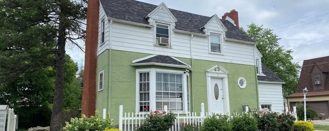 Green and white house white picket fence exterior at Bowers Rentals in Charleston Student Accommodation