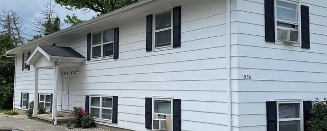 White siding building with multiple windows exterior at Bowers Rentals in Charleston Student Accommodation