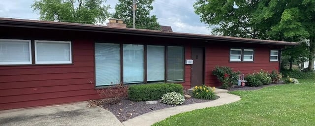 Red siding large windows and green lawn exterior at Bowers Rentals in Charleston Student Accommodation