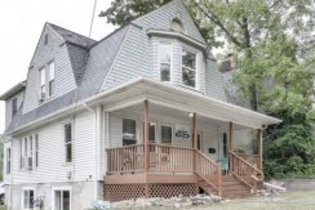 White siding house with dormer roof and porch exterior at Allmand Properties in Ann Arbor Student Accommodation