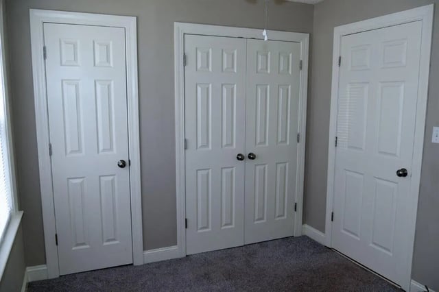 Three white doors and carpet interior photo at Campus Walk at ECU in Greenville Student Accommodation