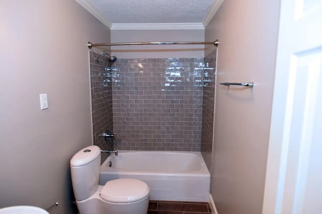 Toilet bathtub grey tile shower rod bathroom at Campus Walk at ECU in Greenville Student Accommodation