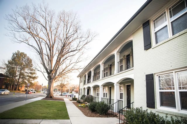 Archway balconies on light green brick building exterior at Campus Walk at ECU in Greenville Student Accommodation