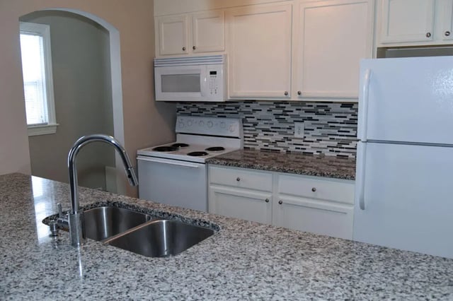 Granite countertops double sink microwave stove refrigerator kitchen at Campus Walk at ECU in Greenville Student Accommodation