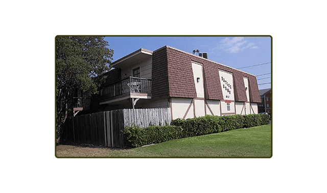 Building with balcony fence and lawn exterior at Baylor Arms in Waco Student Accommodation