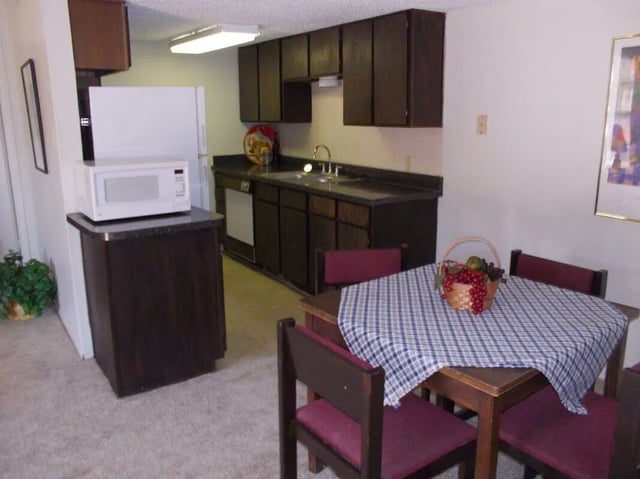 Dining table with fruit basket and chairs kitchen exterior at Baylor Arms in Waco Student Accommodation