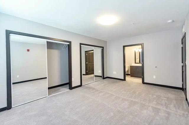Closet with mirrored doors opens to bathroom Bedroom at CitySide By Alexa in Bloomington Student Accommodation