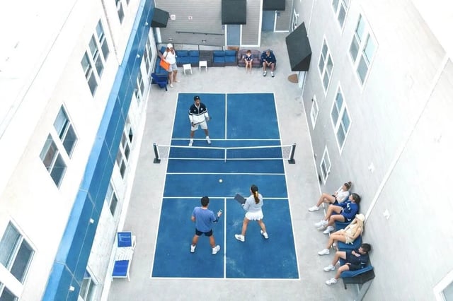 Pickleball court with people playing and watching exterior at CitySide By Alexa in Bloomington Student Accommodation