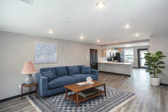 Blue sofa coffee table rug kitchen living room at CitySide By Alexa in Bloomington Student Accommodation