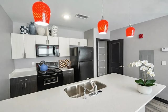 Modern kitchen with white cabinets black appliances and sink kitchen at CitySide By Alexa in Bloomington Student Accommodation