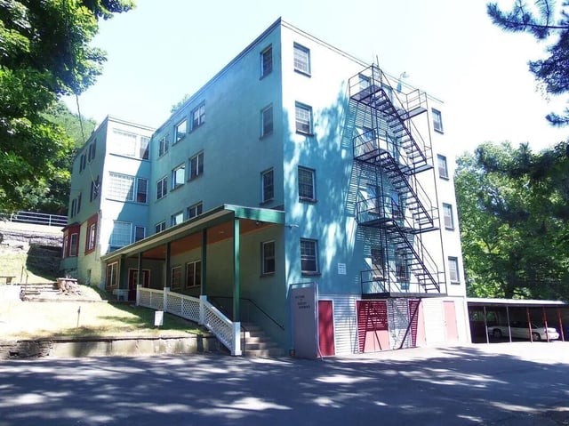 Blue building with fire escape and parking exterior at 407 College Ave in Ithaca Student Accommodation