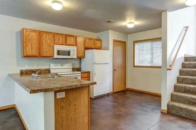 Counter cabinets microwave fridge stairs kitchen at Conifer Creek Townhomes in Allendale Student Accommodation