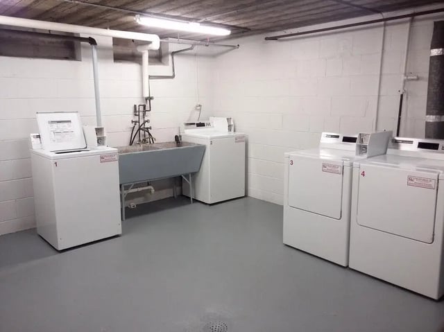 Washing machines dryers and sink laundry room at Campus East in Milwaukee Student Accommodation