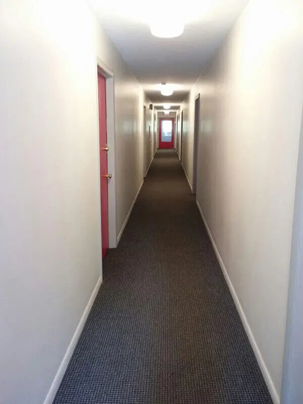 Hallway with doors carpeted floor and lights hallway at Campus East in Milwaukee Student Accommodation