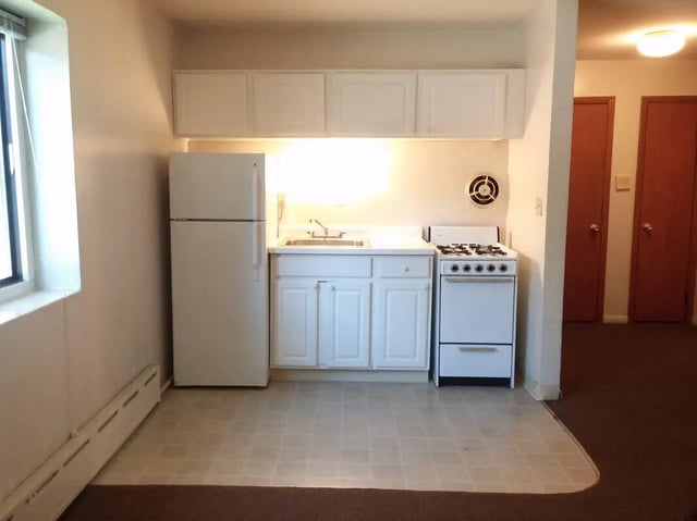 Refrigerator cabinets stove sink kitchen at Campus East in Milwaukee Student Accommodation
