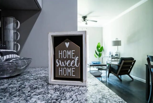 Home sweet home sign with living area Living room at 625 at Prairie View Apartments in Prairie View Student Accommodation