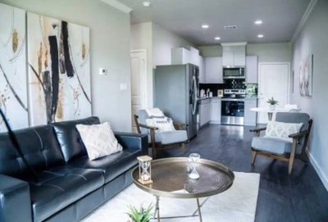 Black leather sofa two chairs kitchen living room at 625 at Prairie View Apartments in Prairie View Student Accommodation