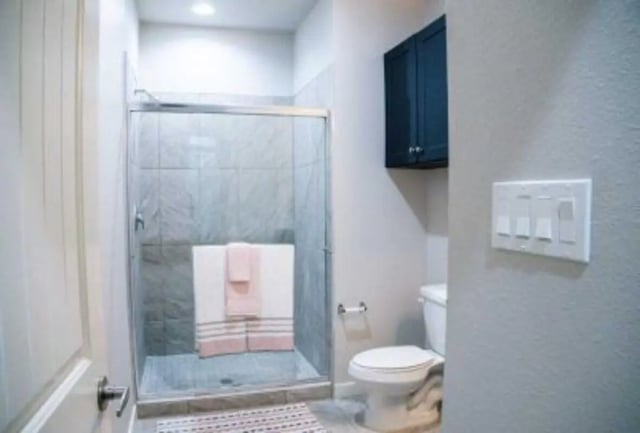 Glass shower toilet dark cabinet bathroom at 625 at Prairie View Apartments in Prairie View Student Accommodation