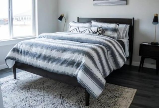 Bed with striped duvet and patterned pillows bedroom at 625 at Prairie View Apartments in Prairie View Student Accommodation