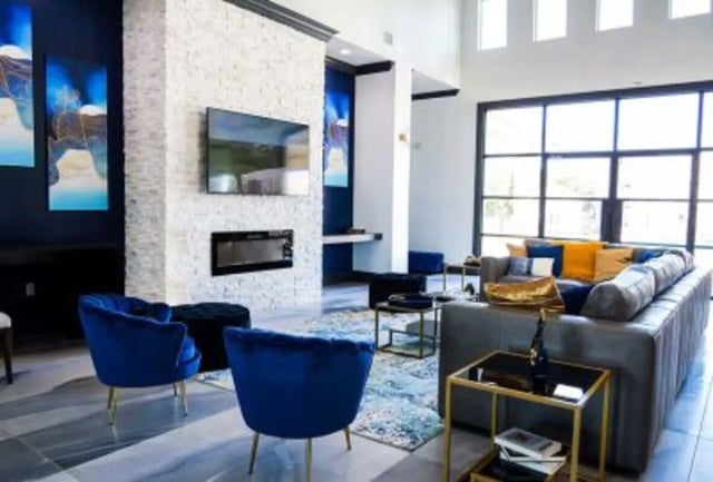 Blue chairs fireplace TV blue art living room at 625 at Prairie View Apartments in Prairie View Student Accommodation