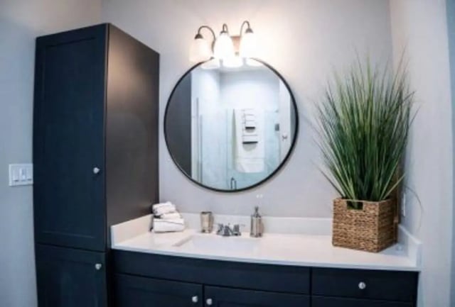 Dark vanity round mirror stacked towels bathroom interior at 625 at Prairie View Apartments in Prairie View Student Accommodation