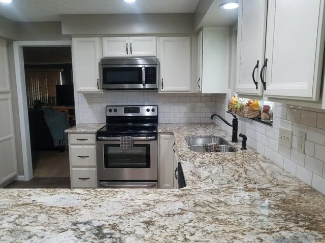 Modern kitchen with stainless steel appliances and white cabinets kitchen at 142 Ashley St - Ashley House Apartments in Dayton Student Accommodation
