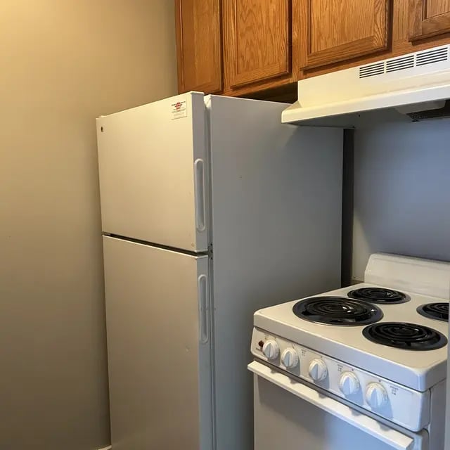 White refrigerator and stove with wooden cabinets kitchen at Adams House in Oxford Student Accommodation