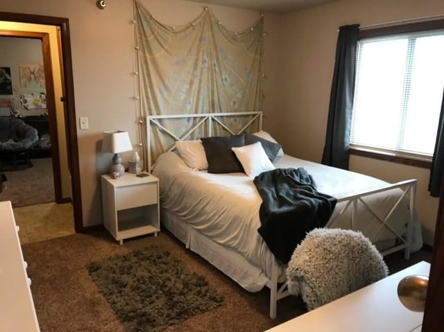 Bed with nightstand and rug Bedroom at Clarks Landing Apartments in Vermillion Student Accommodation