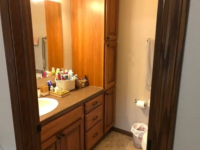 Sink vanity toiletries cabinet toilet waste bin bathroom at Clarks Landing Apartments in Vermillion Student Accommodation
