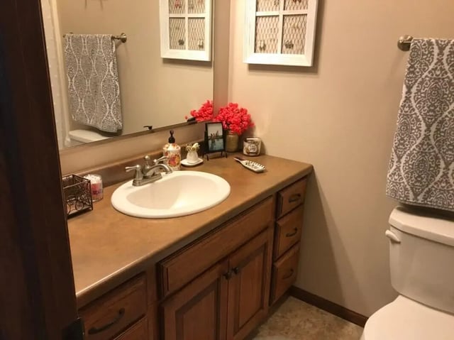 Sink countertop with floral decor and towels bathroom at Clarks Landing Apartments in Vermillion Student Accommodation